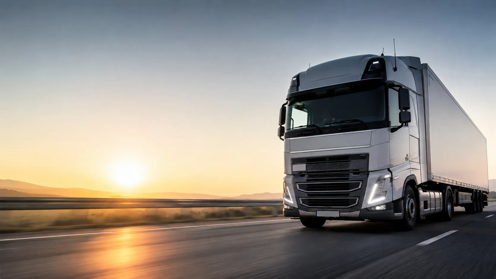 Poids lourd NEWBEE TRANSPORT roulant sur l'autoroute au coucher du soleil